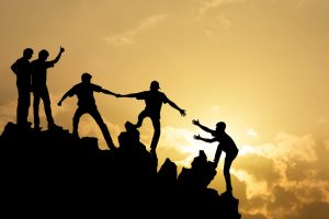 Group of people on peak mountain climbing helping team work , success concept